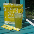 Glass of lemonade with two lemonade packets on a teal chair
